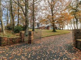 A house with stone wall and gates surrounded by trees at Chapel Hill in Catlowdy