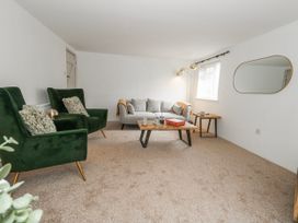 A living room with a sofa and two armchairs at Long Barn in Burton Bradstock