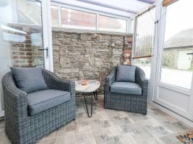 A conservatory with two chairs and a coffee table at Long Barn in Burton Bradstock