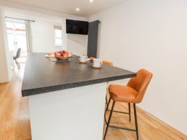 A kitchen with a bar island and coffee cups at Long Barn in Burton Bradstock