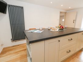 A kitchen with an island and a radiator at Long Barn in Burton Bradstock