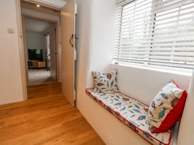 A hallway with a window seat and door at Long Barn in Burton Bradstock