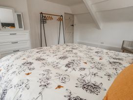 A bedroom with a bed and dresser at Long Barn in Burton Bradstock