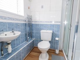 A bathroom with a sink, toilet, and shower at Long Barn in Burton Bradstock