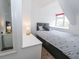 A bedroom with a bed and lamp at Long Barn in Burton Bradstock