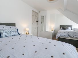 A bedroom with two beds and a lamp at Long Barn in Burton Bradstock