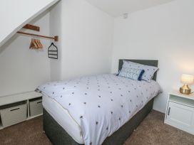 A bedroom with a bed and storage at Long Barn in Burton Bradstock