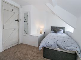 A bedroom with a bed and mirror at Long Barn in Burton Bradstock