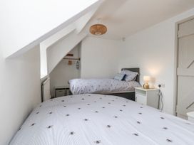 A bedroom with two beds and a lamp at Long Barn in Burton Bradstock
