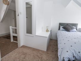 A bedroom with a bed and lamp at Long Barn in Burton Bradstock