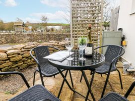 A table with glasses and a wine bottle in an outdoor area at Long Barn in Burton Bradstock