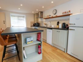 A kitchen with an island, refrigerator, and dishwasher at Long Barn in Burton Bradstock