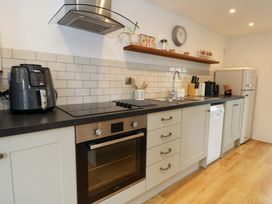 A kitchen with appliances and cabinets at Long Barn in Burton Bradstock