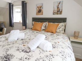 A bedroom with a double bed and artwork on the walls at Long Barn in Burton Bradstock