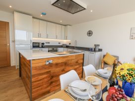 A kitchen with a dining table and kitchen island at Seafern House 36B Poole