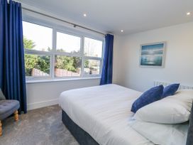 A bedroom with a bed and windows at Seafern House 36B in Poole