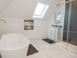 A bathroom with a bathtub, shower, and sink at Seafern House 36B in Poole