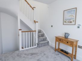 A hallway with a staircase and a console table at Seafern House 36B in Poole
