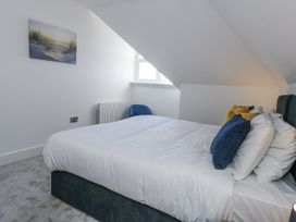 A bedroom with a bed and chair at Seafern House 36B in Poole