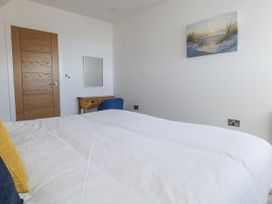 A bedroom with a bed and wooden furniture at Seafern House 36B in Poole