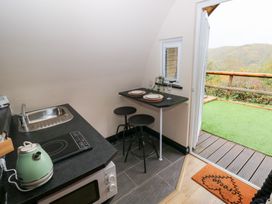 A kitchen with a sink and dining area at Cwtch Bach in Aberdare