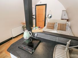 A studio with a kitchenette and bed at Cwtch Bach Aberdare