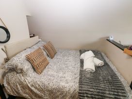 A bedroom with a bed and towels at Cwtch Bach in Aberdare