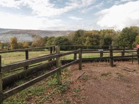 An outdoor area with a fence and parking signs at Cwtch Bach Aberdare