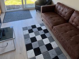 A living room with a brown sofa and a patterned rug at Stanbury