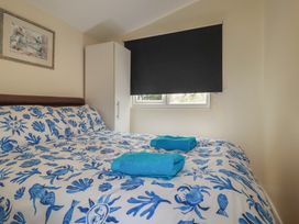 A bedroom with a bed and wardrobe at Stanbury in St Merryn