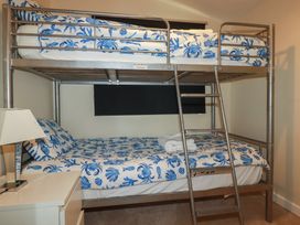 A bunk bed with patterned bedding and a lamp at Stanbury in St Merryn
