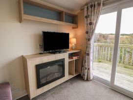 A living room with a television and fireplace at Peaceful in Stranraer