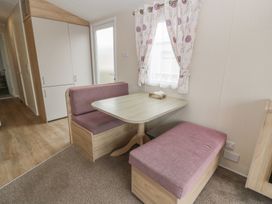 A dining area with a table and benches at Peaceful in Stranraer