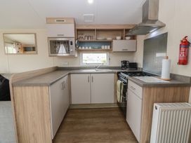 A kitchen with sink, oven, and microwave at Peaceful in Stranraer