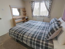 A bedroom with a bed and mirror at Peaceful in Stranraer