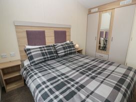 A bedroom with a double bed and wardrobe at Peaceful in Stranraer
