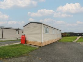 A static caravan with gas cylinders in an outdoor area at Peaceful in Stranraer