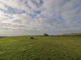 A grassy area with a bench and building at Peaceful in Stranraer