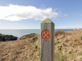 A signpost for Rhins of Galloway Coast Path near the ocean at Peaceful in Stranraer