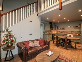 A living room with a sofa and a kitchen area at Robins Rest at The Lodge Kilmacthomas
