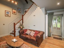 A living room with a sofa and staircase at Robins Rest at The Lodge Kilmacthomas