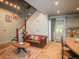 A living room with a staircase and a dining area at Robins Rest at The Lodge Kilmacthomas