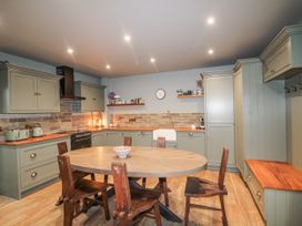 A kitchen with cabinets and a dining table at Robins Rest at The Lodge Kilmacthomas