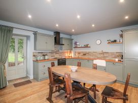 A kitchen with a table and chairs near a sink and stove at Robins Rest at The Lodge Kilmacthomas