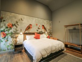 A bedroom with a bed and wall decor featuring birds and flowers at Robins Rest at The Lodge Kilmacthomas