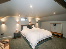A bedroom with a bed and a clothes rack at Robins Rest at The Lodge in Kilmacthomas