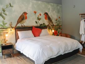 A bedroom with a bed and wall art at Robins Rest at The Lodge Ahanaglogh near Kilmacthomas, County Waterford