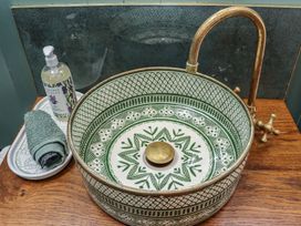 A sink with a soap dispenser and towel at Robins Rest at The Lodge Ahanaglogh near Kilmacthomas, County Waterford
