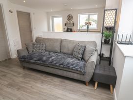 A living room with a couch and table at Cosy Retreat