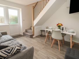 A dining area with a table and chairs adjacent to a sofa at Cosy Retreat 